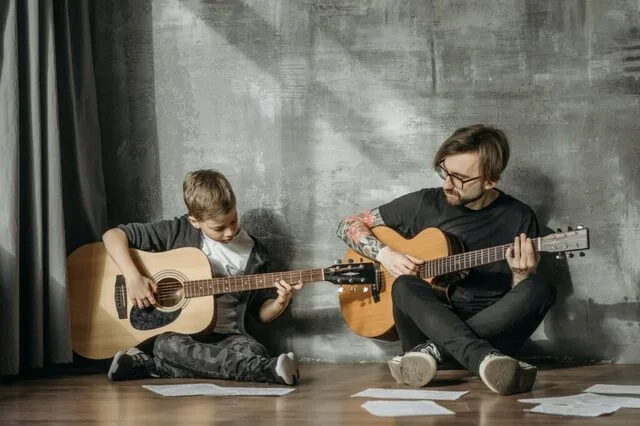father and son playing guitar