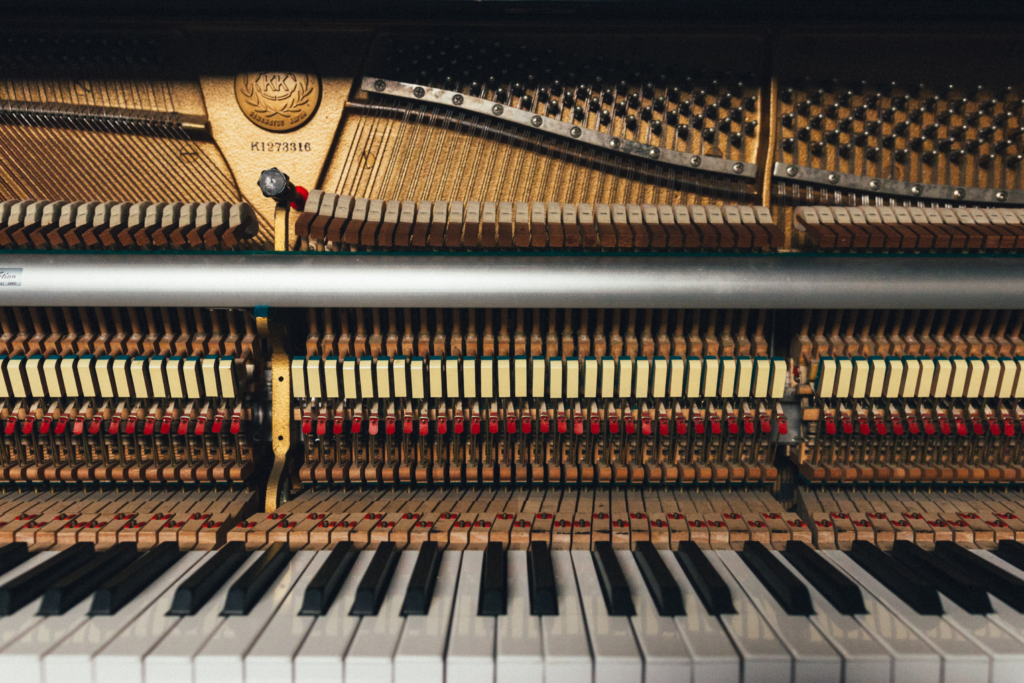 A piano keyboard with an open soundboard