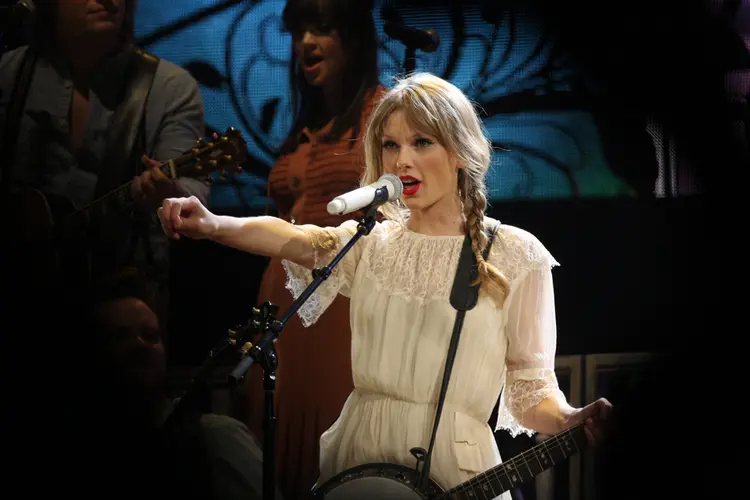 Taylor Swift singing in a concert.