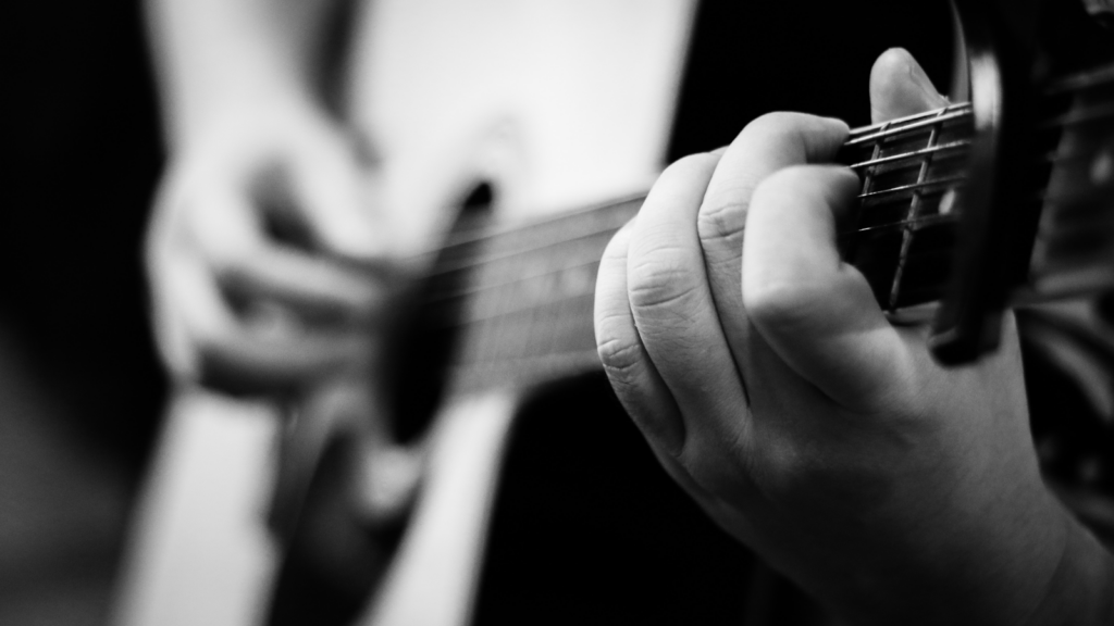 Close up of a guitarist playing chords.