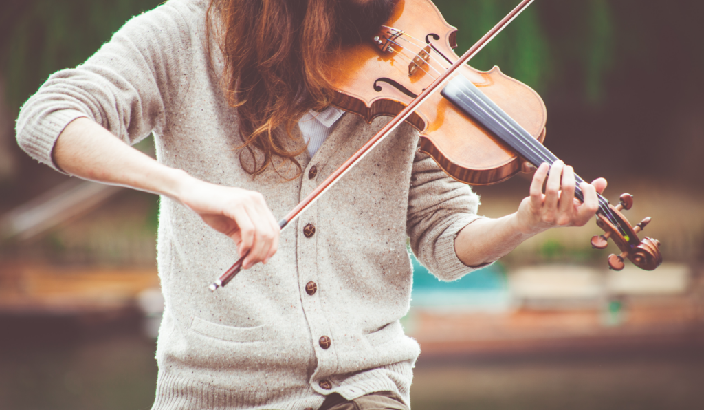 A woman in a grey jersey playing the violin