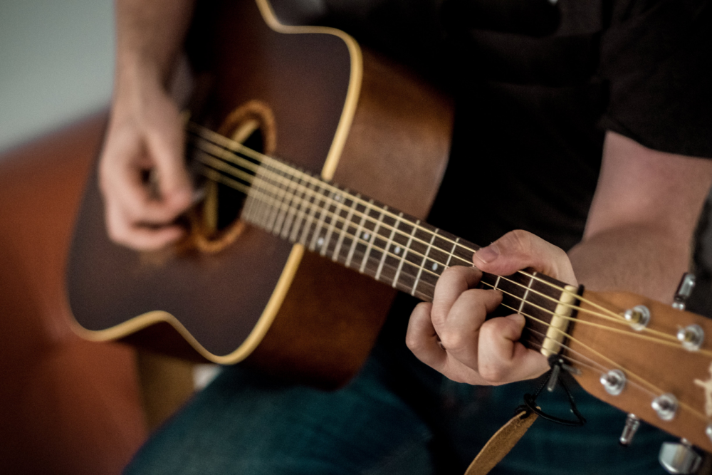 Close up of a man playing an acoustic guitar