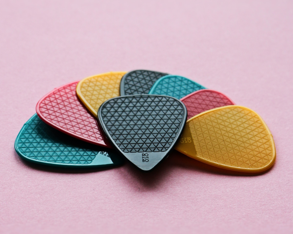 A variety of standard guitar picks in different colors.