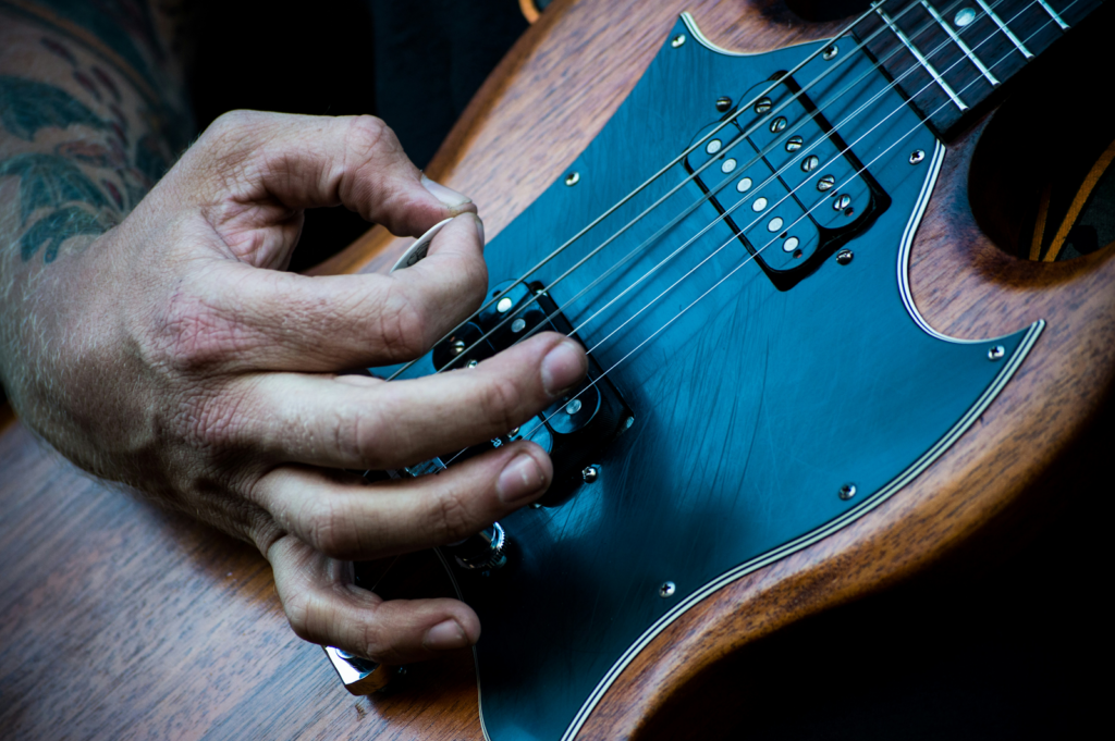 A guitarist using a guitar pick.