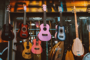A variety of different types of guitars on display in a store.