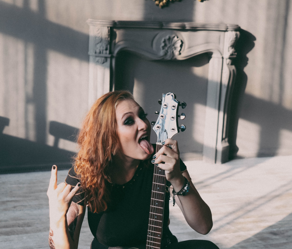 A female rock star posing with her guitar