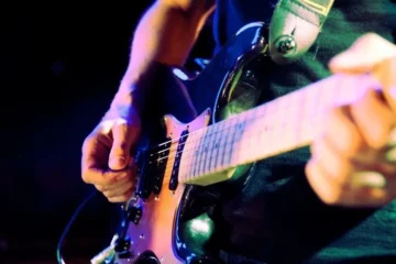 An artist playing a metal guitar.
