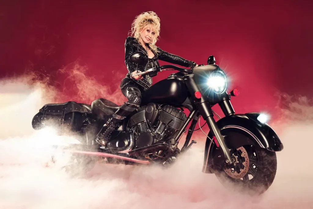 Dolly Parton posing on a motorbike.