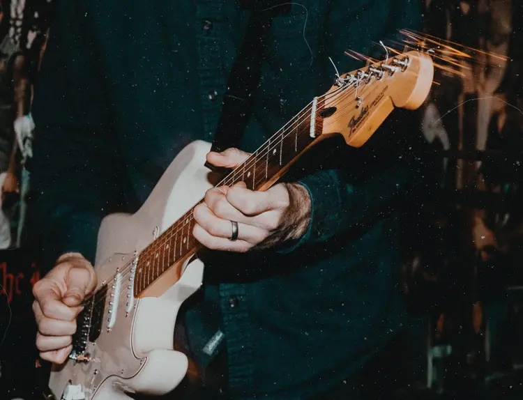A white electric guitar being played