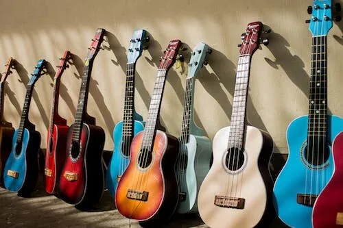 A row of different colored guitars.