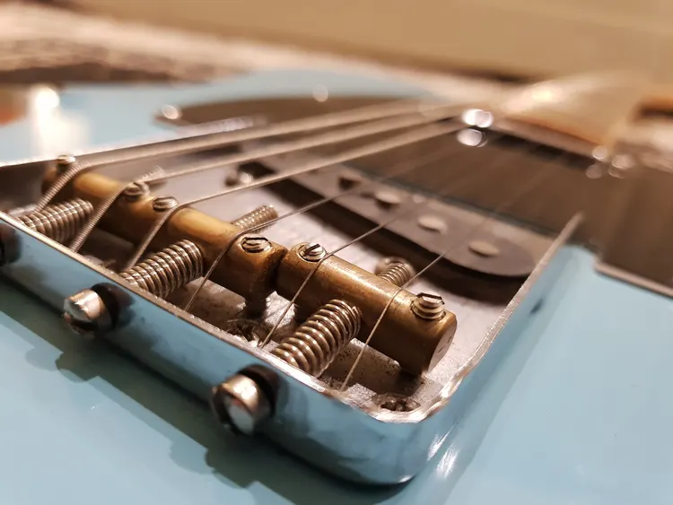 An image of the steel strings of an electric guitar.