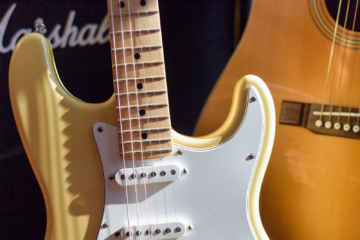 A close up of an electric guitar and a Marshal amp.