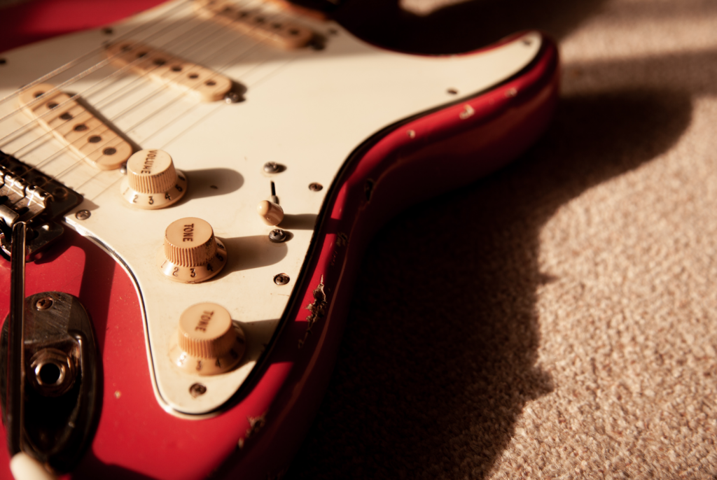A close up of an electric Fender guitar.