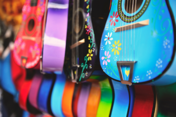 A variety of multi colored guitars on display.