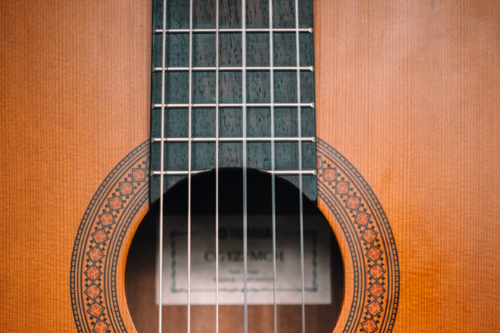 Close up of the soundboard of an acoustic guitar with nylon strings.