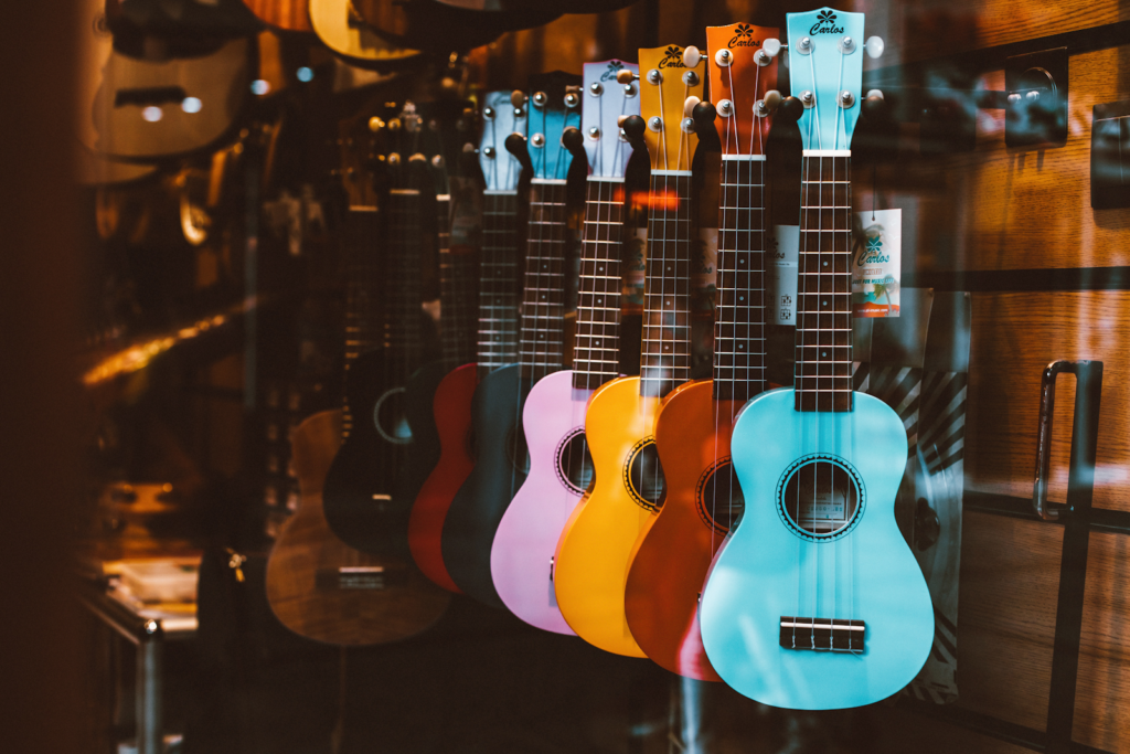 Guitars of different colors hanging on display in a store.