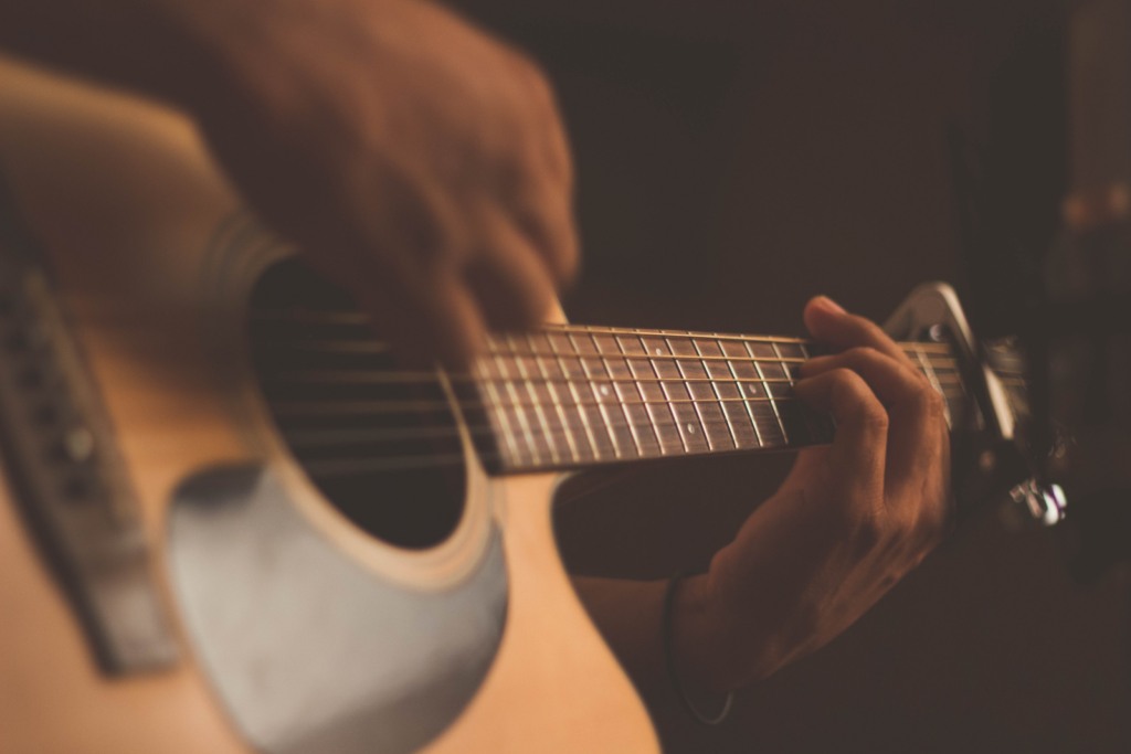A close up of an acoustic guitar being strummed.