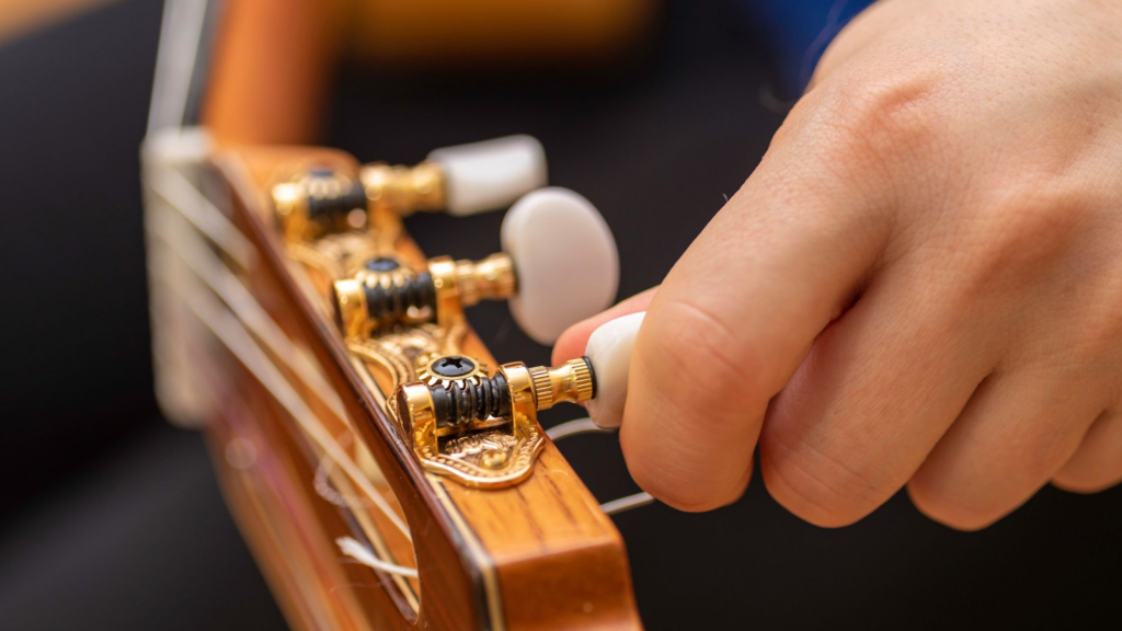 A close up of the tuning pegs of a guitar. 