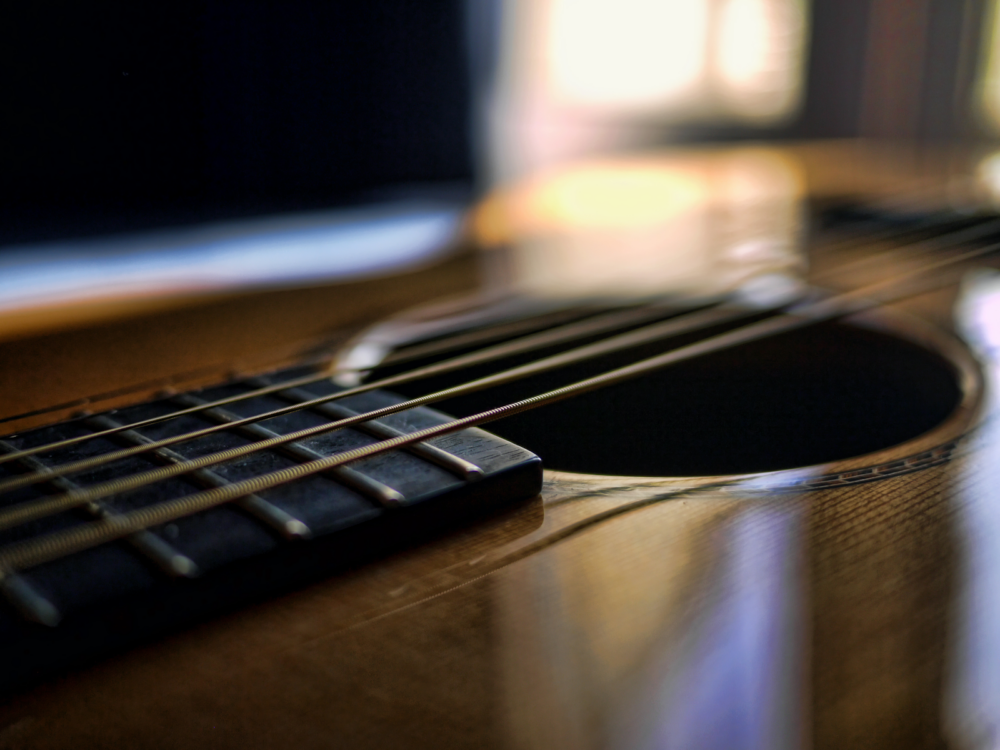 A close up of the soundboard of an acoustic guitar.