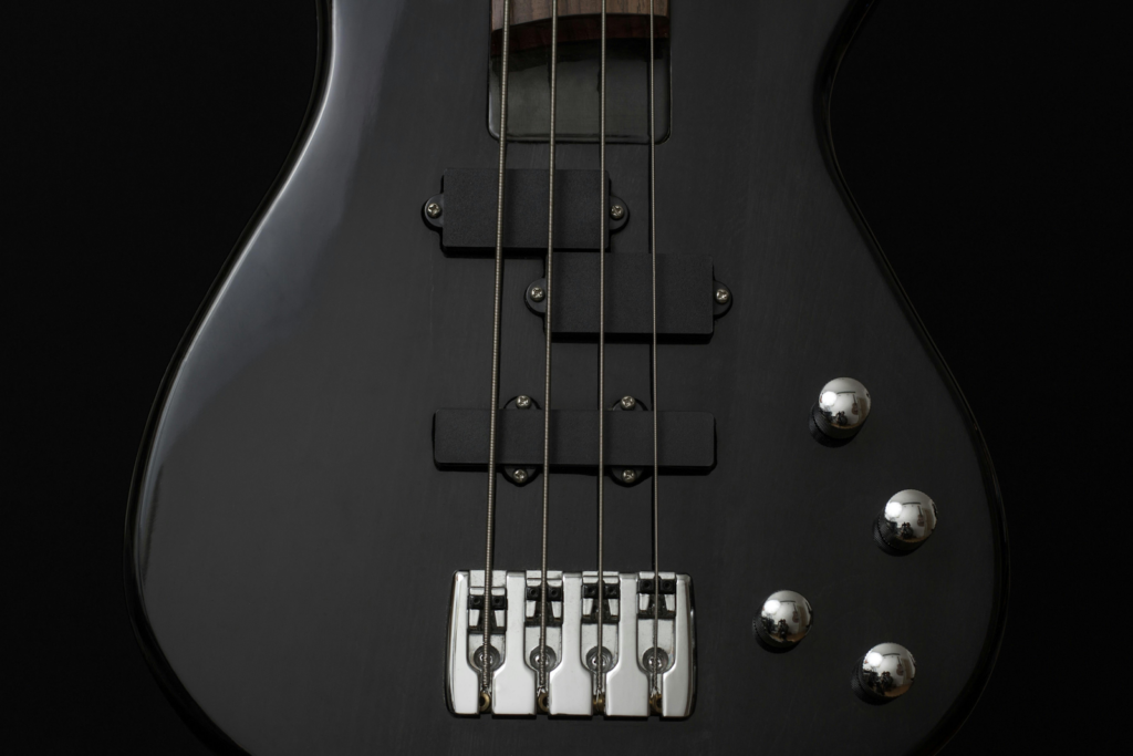 A close up a bass guitar, in shades of black.