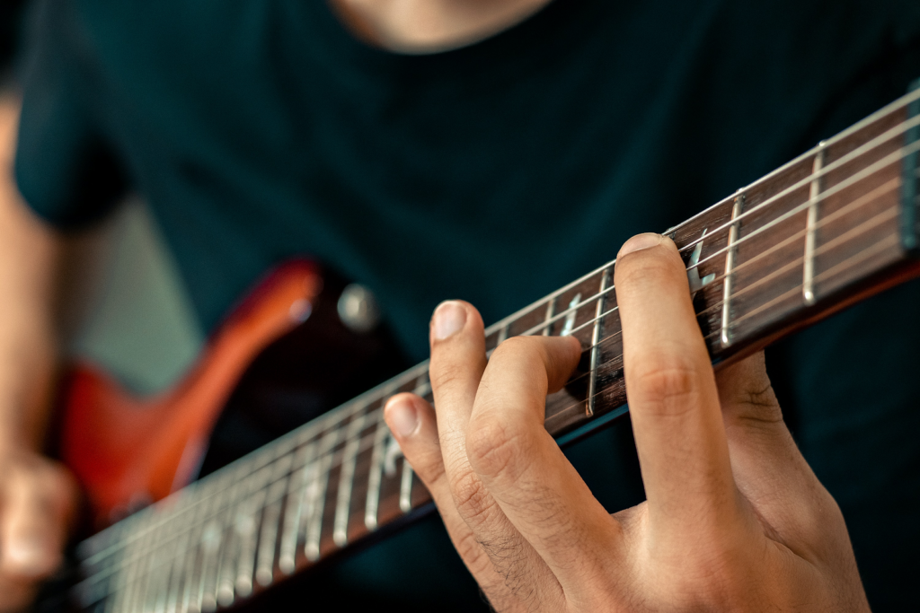 A close up of a fretboard of a guitar.