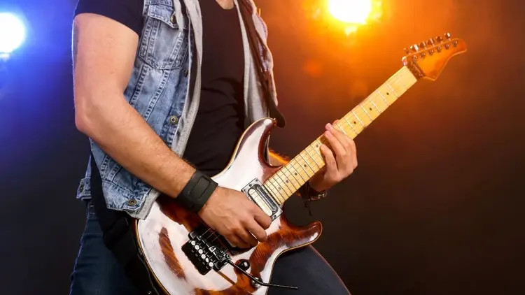 A man playing a guitar on stage. 