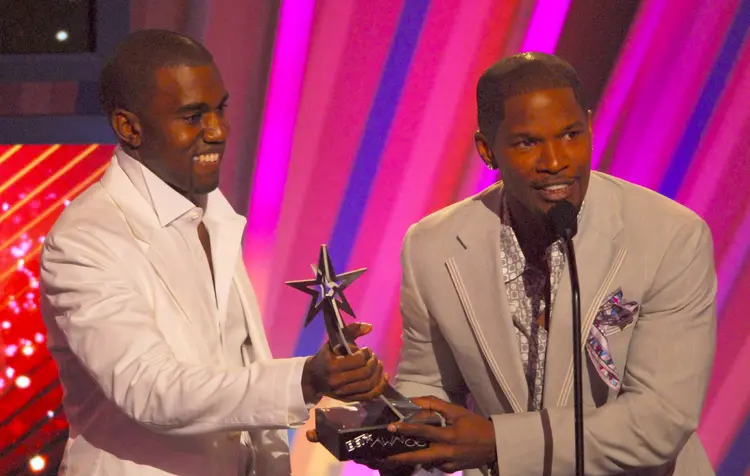 Kanye West and Jamie Foxx accepting an award.