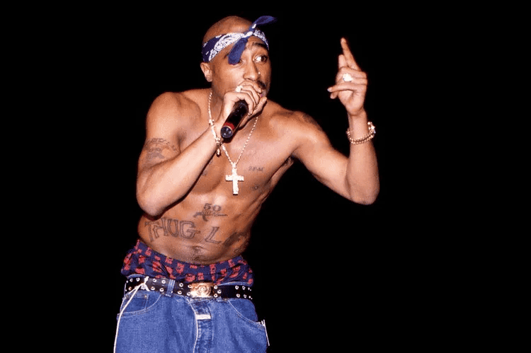 Tupac Shakur performing on stage.