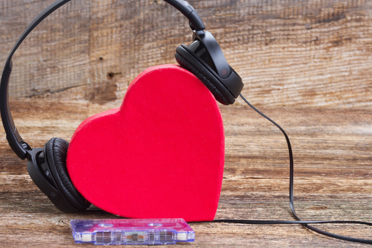 A set of headphones and a red heart, depicting songs about love.