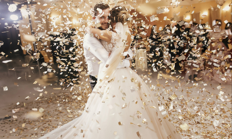 A bride and bridegroom celebrate with confetti on their wedding day.